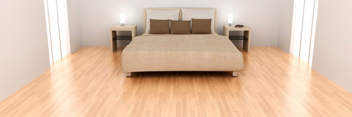 A modern bedroom with electric radiant floor heating installed beneath light-colored hardwood flooring.