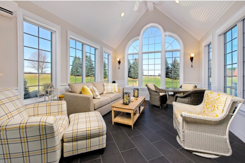 A sunroom with dark grey tiled floors featuring an installed electric radiant floor heating system.