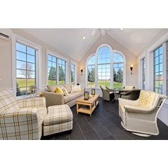 A sunroom with dark grey tiled floors featuring an installed electric radiant floor heating system.