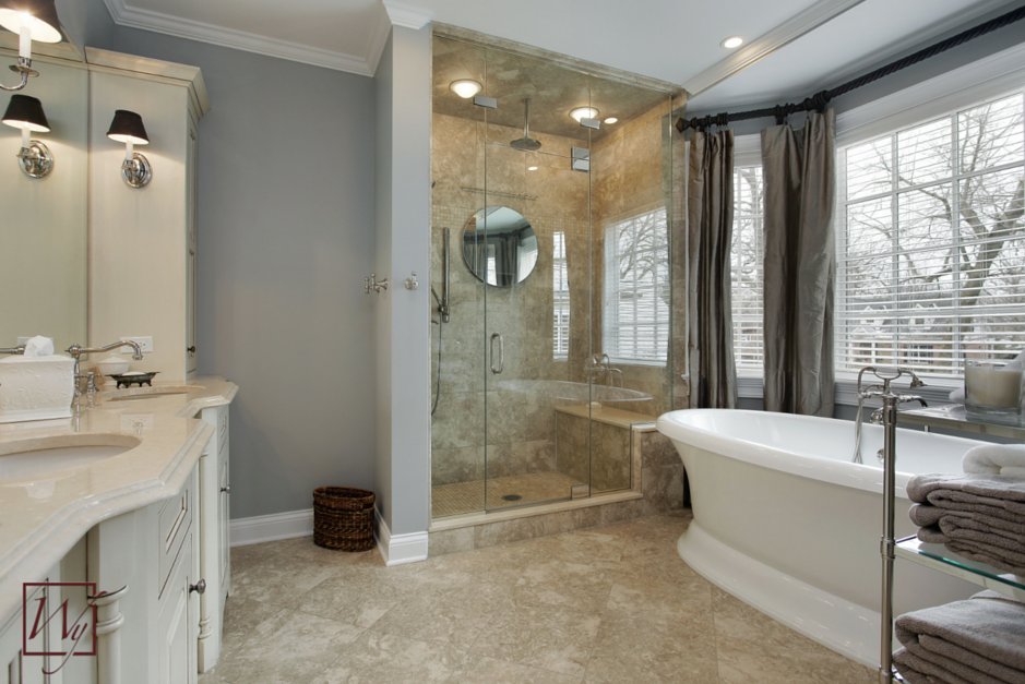 A spacious master bathroom featuring a freestanding soaking tub and stone tile floors equipped with an electric radiant floor heating system.