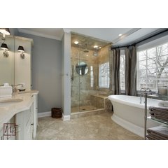 A spacious master bathroom featuring a freestanding soaking tub and stone tile floors equipped with an electric radiant floor heating system.