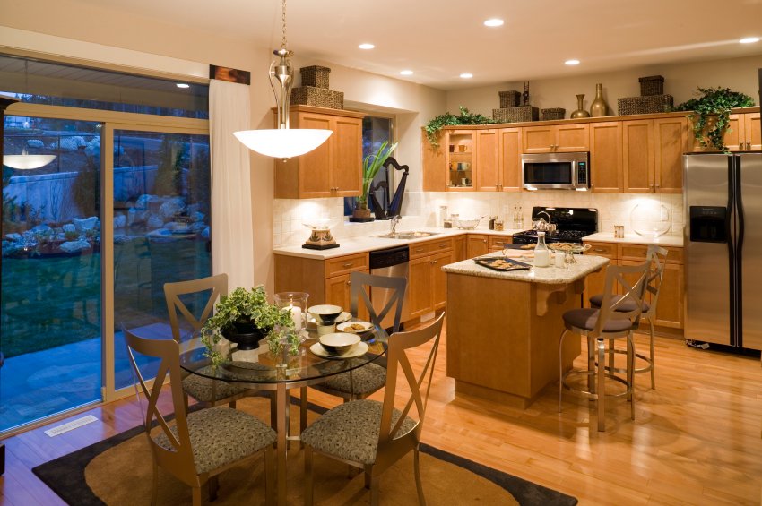A modern open-concept kitchen and dining area featuring light hardwood flooring suitable for electric radiant floor heating.
