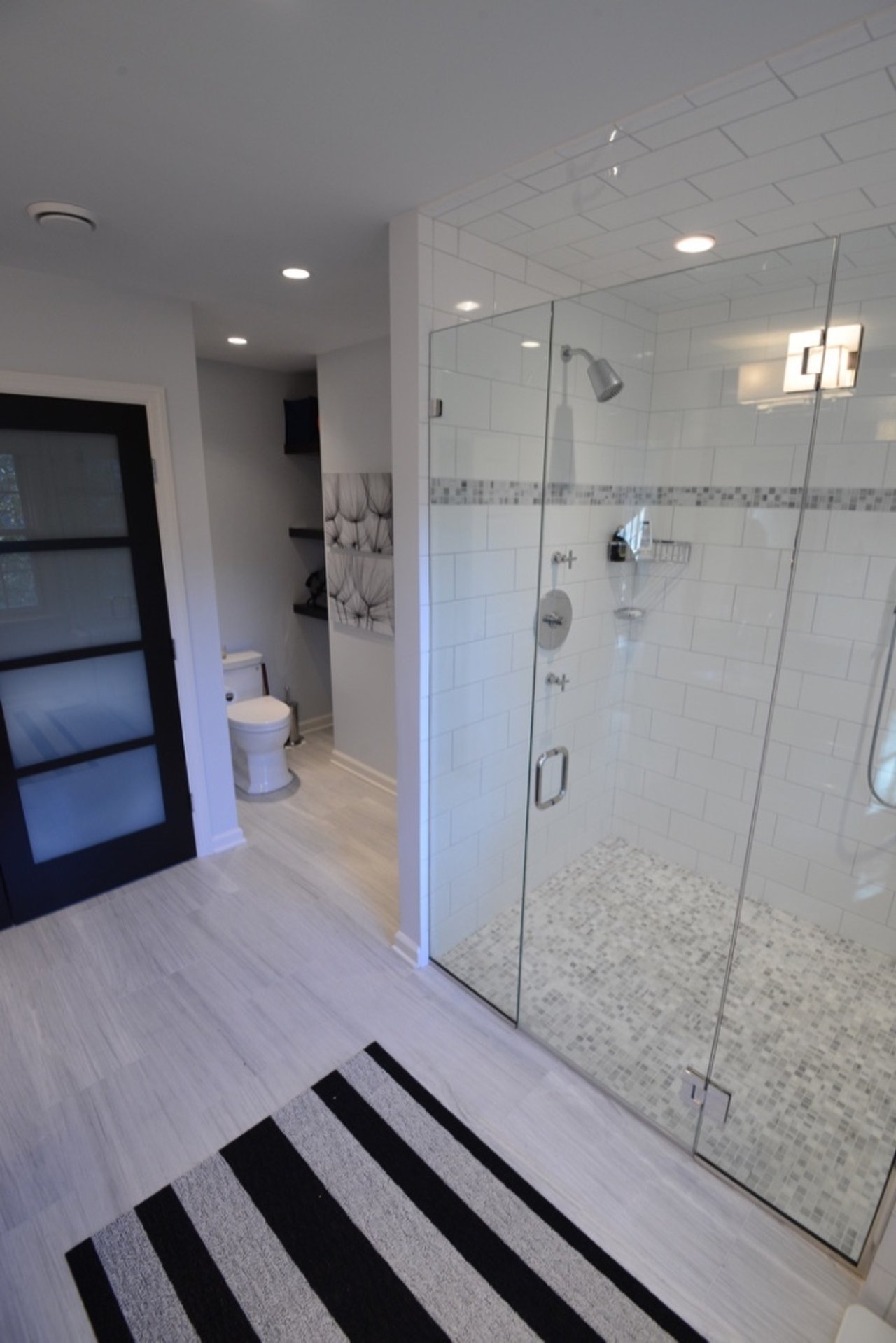 Finished luxury bathroom remodel in New Canaan featuring a walk-in tile shower and radiant wood-look flooring.