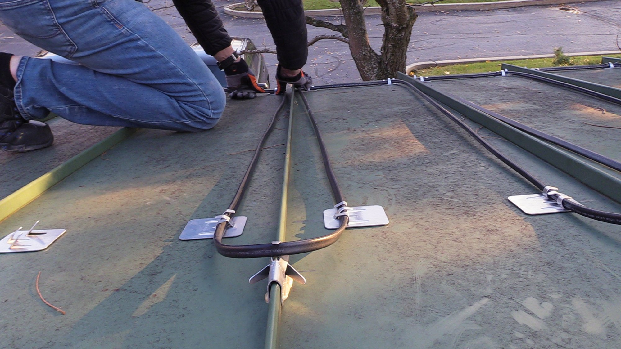 Roof and Gutter installation for WarmlyYours Office securing cable into clips