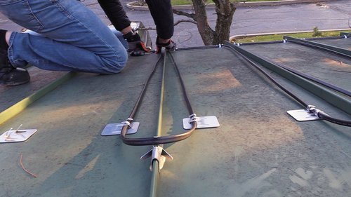 Roof and Gutter installation for WarmlyYours Office securing cable into clips