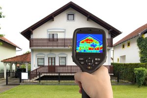 A thermal imaging camera displaying heat distribution patterns on a residential house to evaluate energy efficiency.