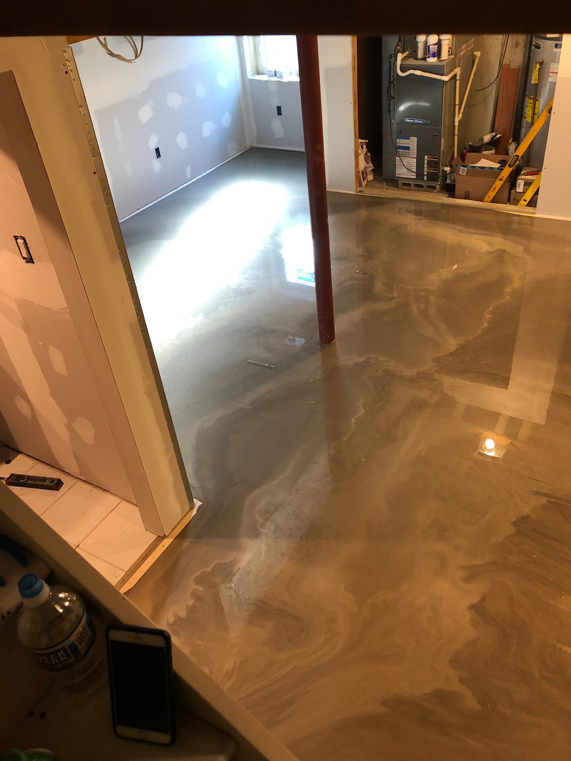 Self leveling cement being applied over TempZone Flex Roll in a Basement