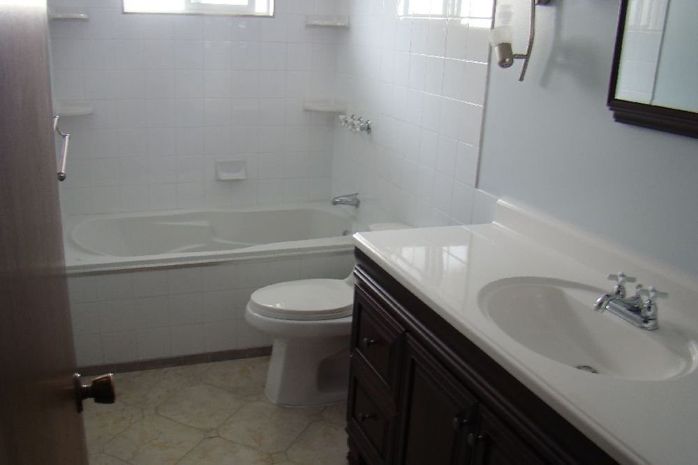 A finished bathroom with tan patterned tile flooring installed over an electric radiant floor heating system.