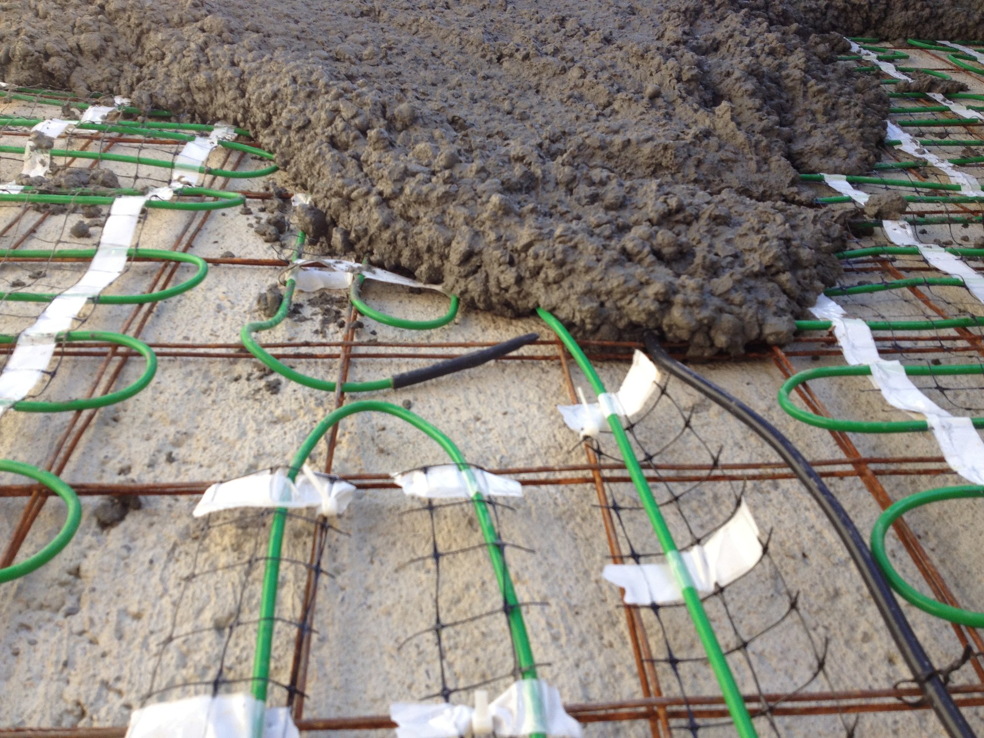 Snow Melting Install for Heated Concrete Driveway spreading concrete over heating mats