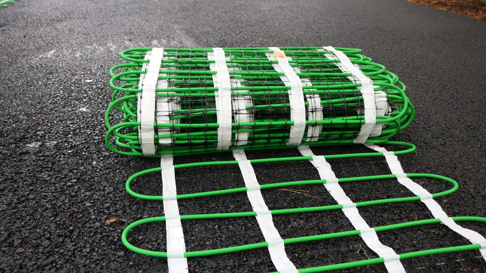 Snow melting mat unrolled on asphalt