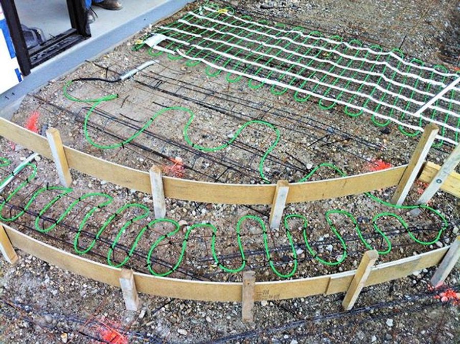 Snow melting system cable secured over rebar grid for a curved concrete ramp installation in Lake Zurich, IL.