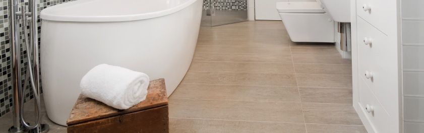 A contemporary spa bathroom with light beige tile flooring featuring concealed electric radiant floor heating.