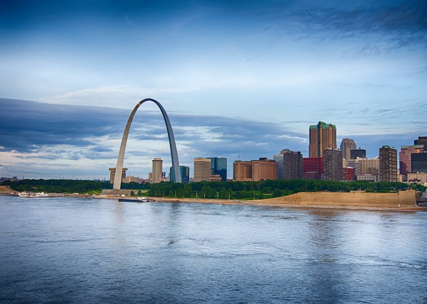 The St. Louis skyline and Gateway Arch viewed across the Mississippi River at dusk.
