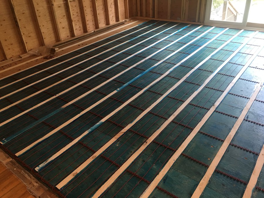 TempZone radiant heating cable installed between wood sleepers for hardwood floor warming.