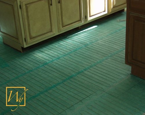 Electric floor heating mat being installed on a bathroom subfloor