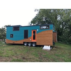 Exterior of a custom tiny house on a trailer featuring concealed electric radiant floor heating.
