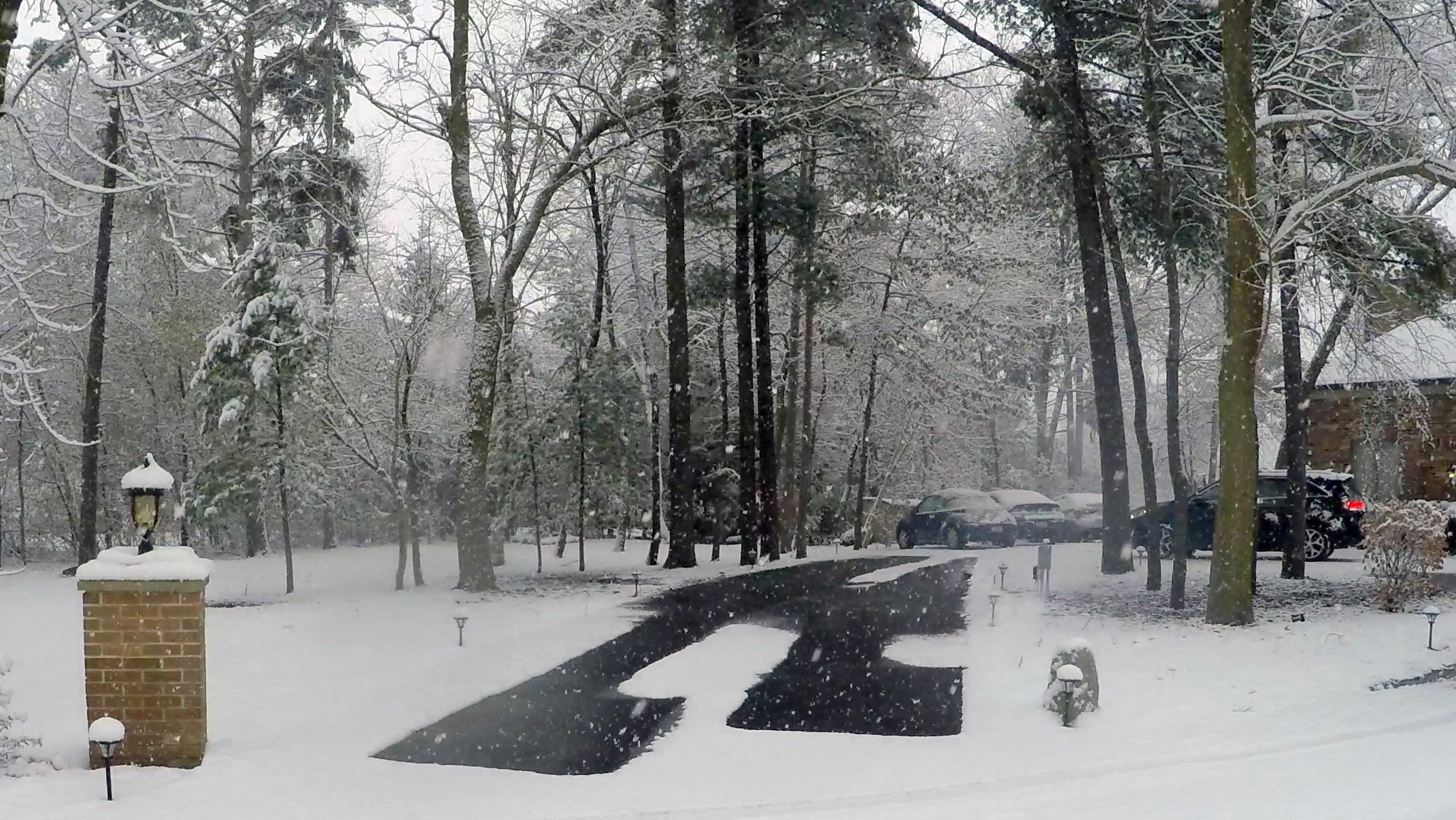 Tire tracks snow melting in a driveway
