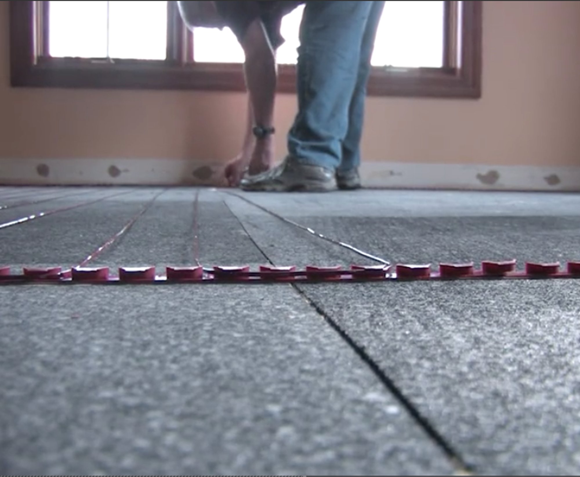 TZ cable being installed with ThermalSheet in basement