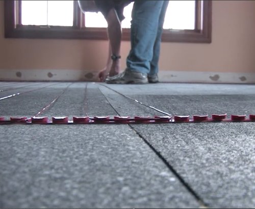 TZ cable being installed with ThermalSheet in basement