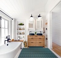 Underfloor heating installed in a tile bathroom with vanity, mirrors and tub.