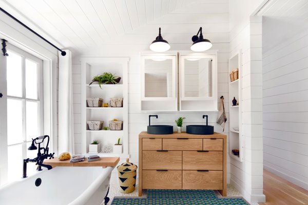 Underfloor heating installed in a tile bathroom with vanity, mirrors and tub.