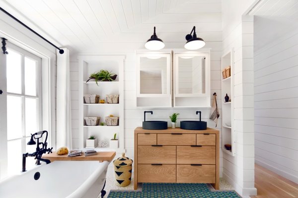 Underfloor heating installed in a tile bathroom with vanity, mirrors and tub.