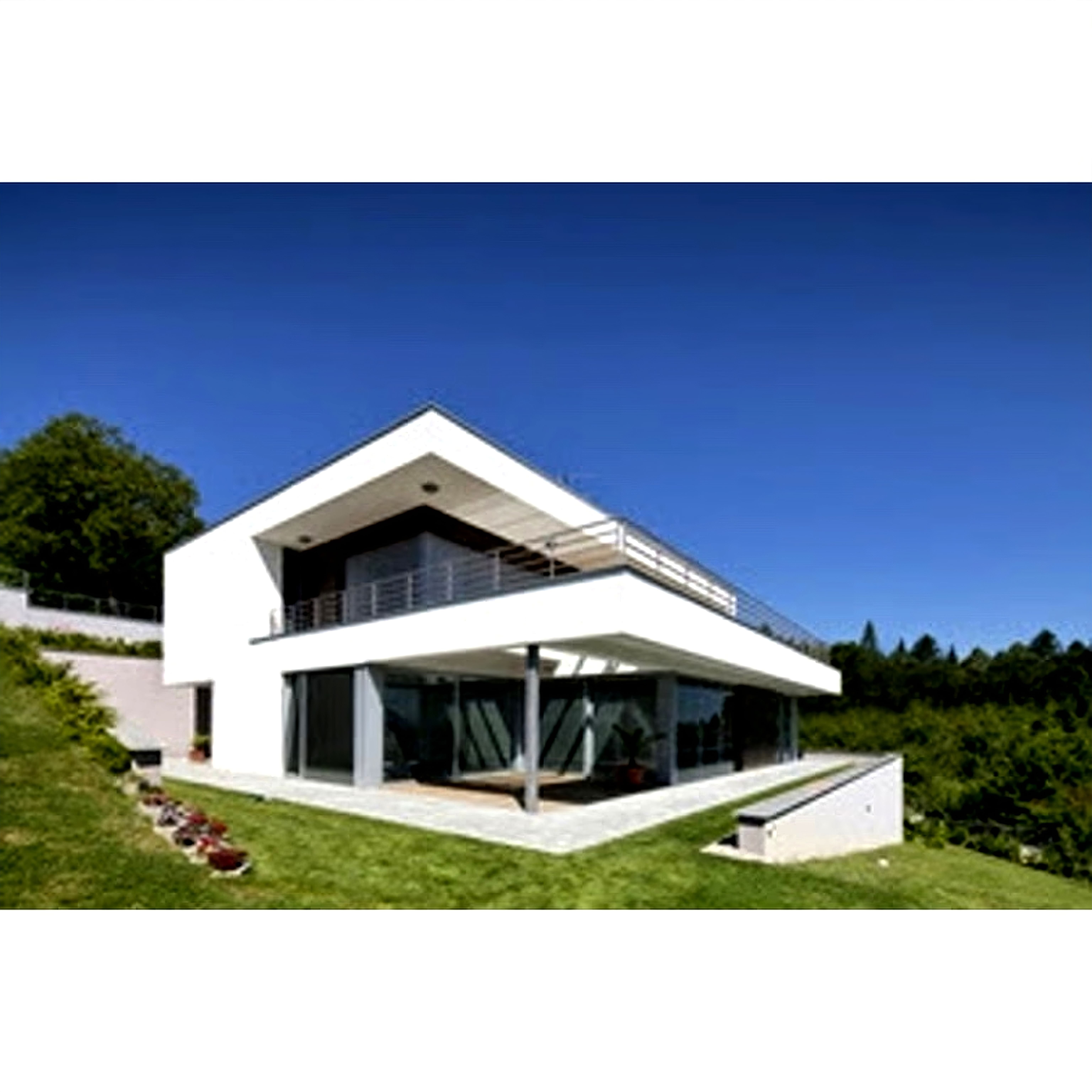 A modern multi-story home with geometric white architecture and large glass windows situated on a sloping green lawn.