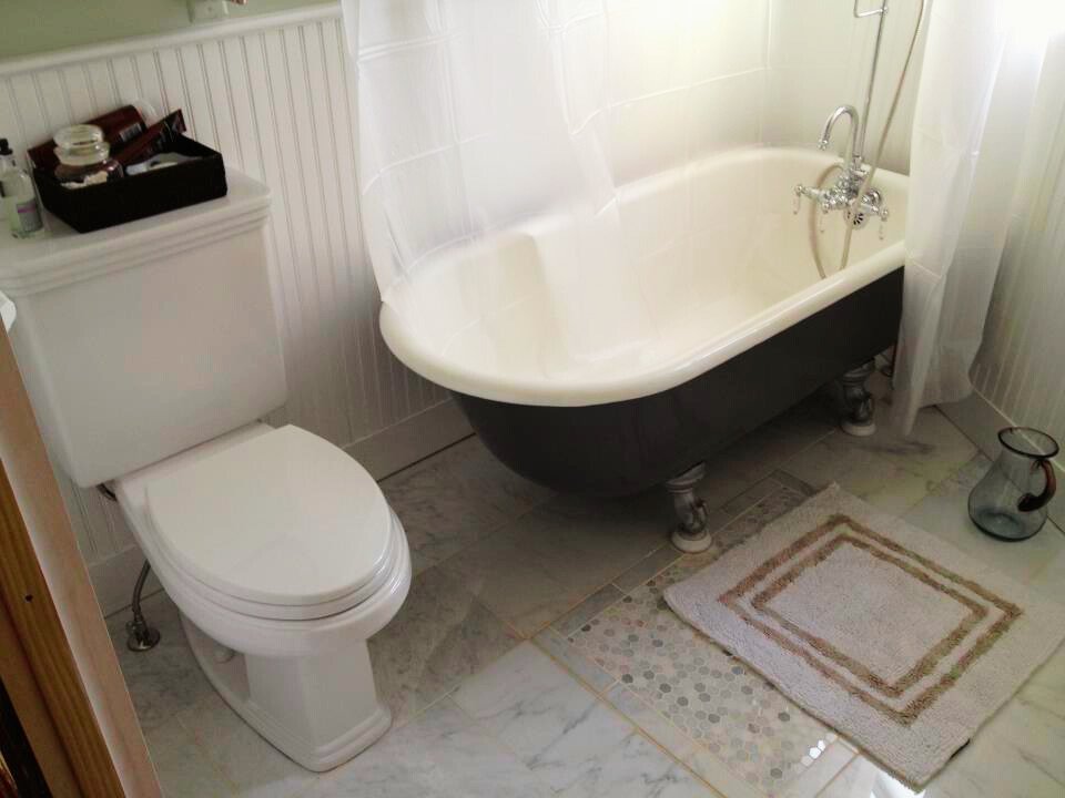 Radiant heated bathroom in historic Washington D.C. home with clawfoot tub and modern towel warmer.