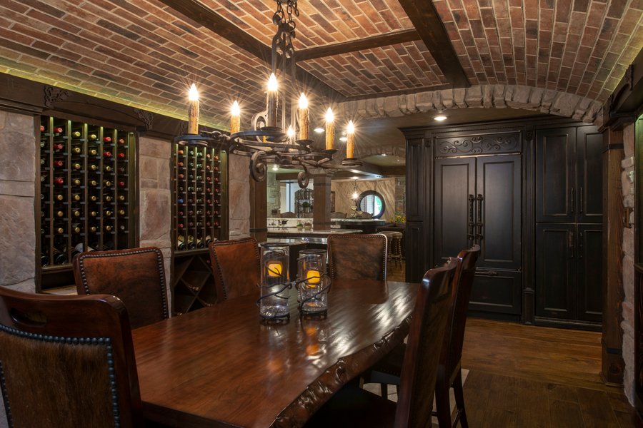 Wine cellar dining room with heated wood floors by Architectural Justice