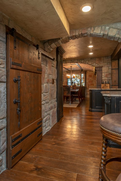 Wine room, bar and kitchen with heated wood floors by Architectural Justice