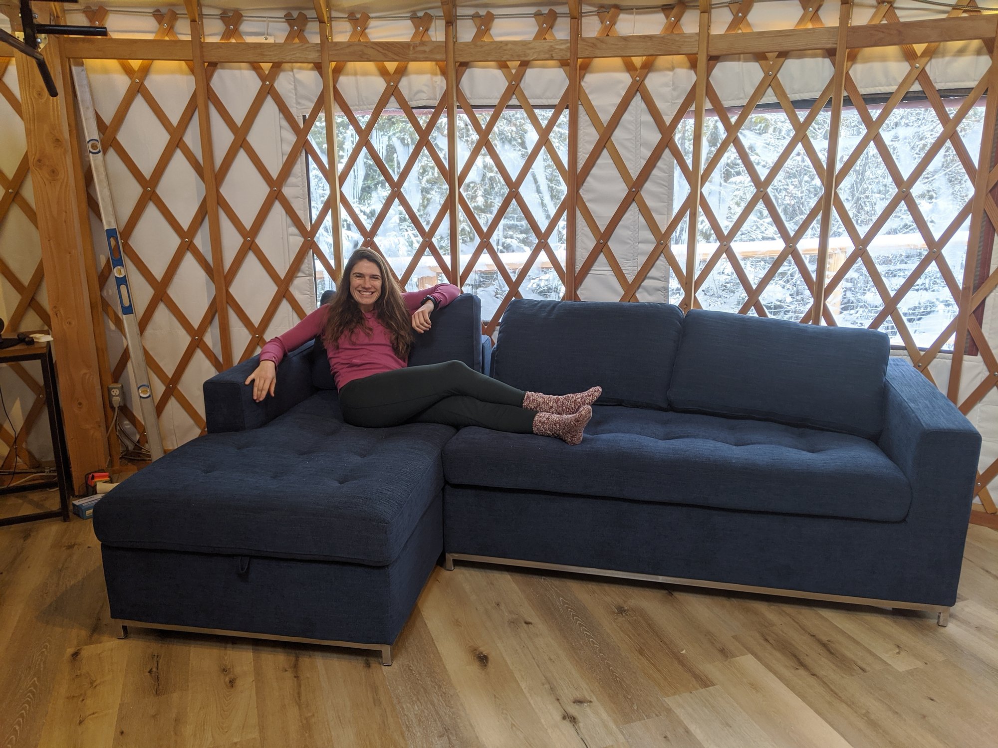 Yurt floor heating project done showing katie on couch